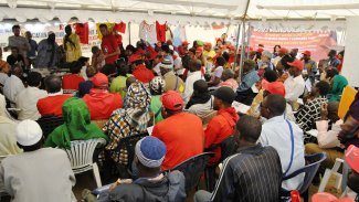 View from the back of an event space in a marquee with attendees facing forward to the speaker